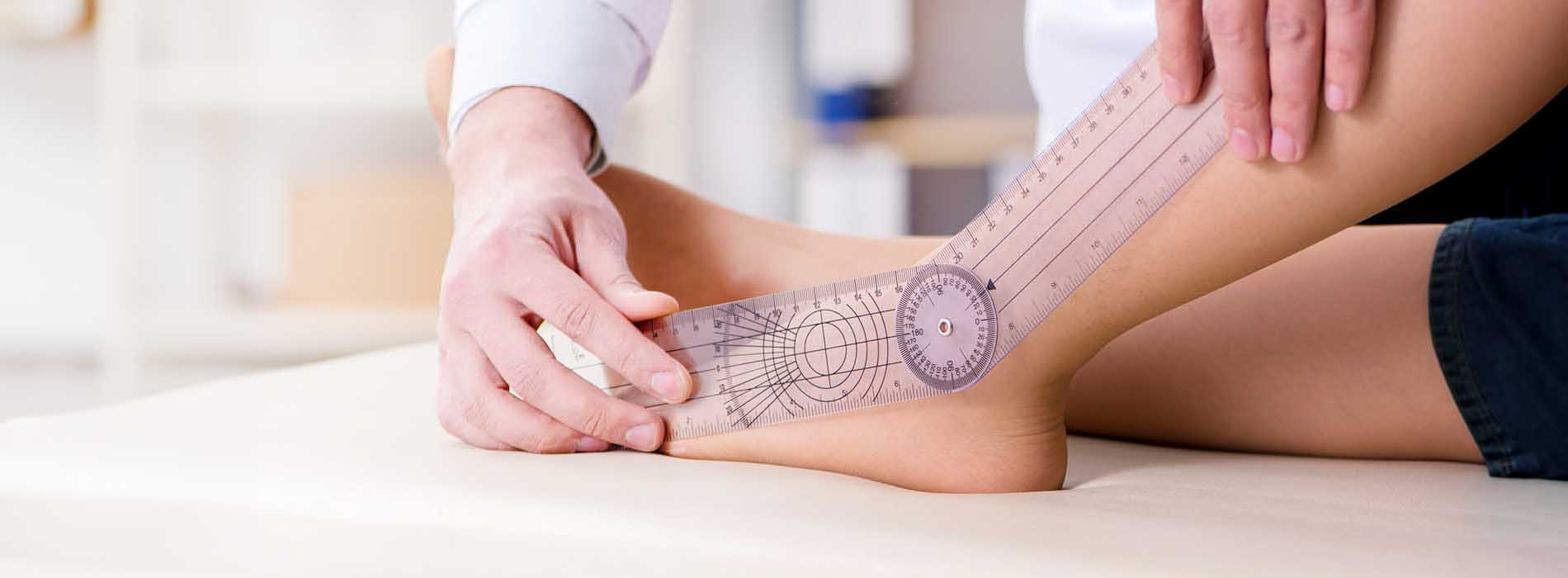 A person s foot is being measured with a device by another person, who appears to be a professional, likely in a medical or podiatry setting.